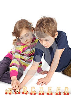Boy and girl playing with wooden railway
