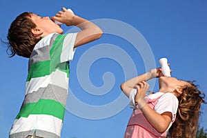 Boy and girl with pleasure drink yoghurt photo