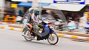 A boy and girl riding on a motorcycle.Blurred motion