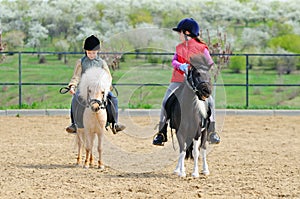 Boy and girl riding ponies