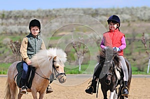 Boy and girl riding ponies