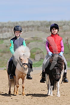 Boy and girl riding ponies