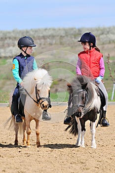 Boy and girl riding ponies