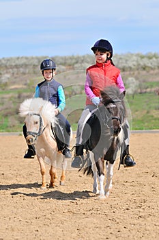 Boy and girl riding ponies