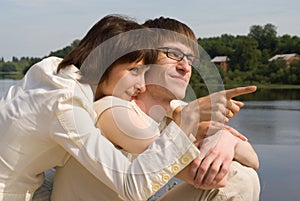 Boy and girl on the river`s bank