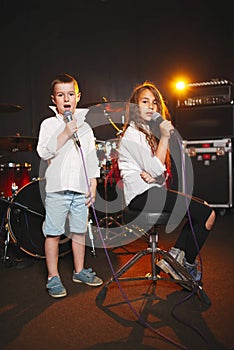 Boy and girl singing in recording studio