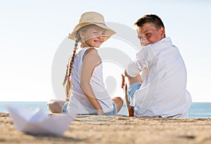 Boy and girl sitting beach