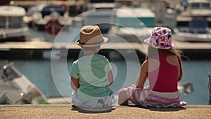 Boy and girl sitting on a pier