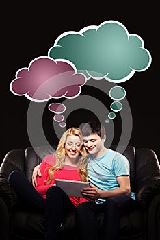 Boy and girl sitting together with a tablet pc and watching a mo