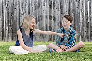 Boy and girl sitting on yard
