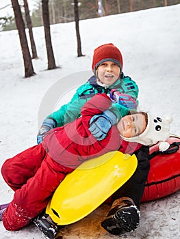 Boy and girl sliding on snow tubing