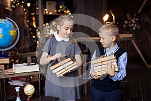 Boy and girl with a stack of books comes from the library. Smart schoolboy and schoolgirl. Literature lesson