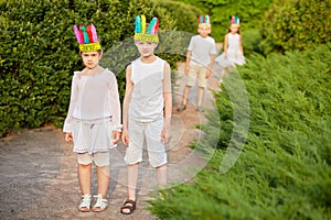 Boy and girl in stylized indian headdress stand on photo