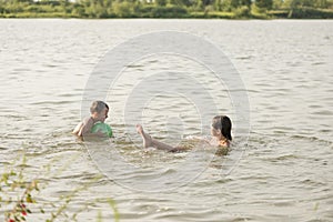 Boy and girl swimming in a pond