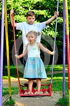 The boy and the girl on a swing