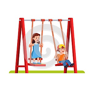 Boy and girl swinging on swing on playground