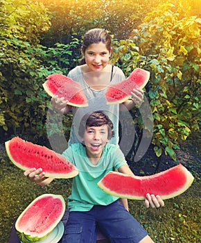 Boy and girl teen have fun eating water melon