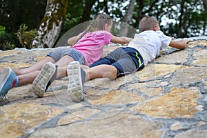 Boy and girl play on mountain. children tourists travelers climb mountain.