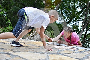 Boy and girl play on mountain. children tourists travelers climb mountain.