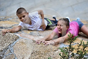 Boy and girl play on mountain. children tourists travelers climb mountain.