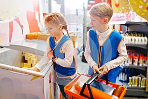 Boy and girl in uniform playing sellers, playroom