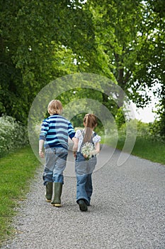 Boy And Girl Walking On Country Lane