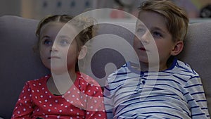 Boy and girl watching tv at night, scared when parents suddenly return home