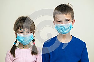 Boy and girl wearing blue protective medical mask ill with chickenpox, measles or rubella virus with rashes on body. Children