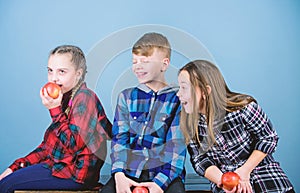 Boy and girls friends eat apple snack while relaxing. Healthy dieting and vitamin nutrition. School snack concept. Group