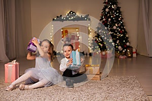 Boy and girls open Christmas presents new year Christmas tree