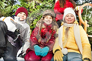 Boy and girls sitting together outside in snow