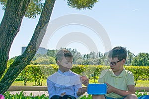 Boy gives an apple to a girl resting in the fresh air
