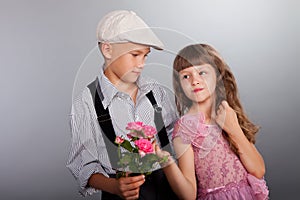 The boy gives a flower to the girl