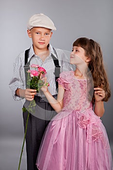 The boy gives a flower to the girl