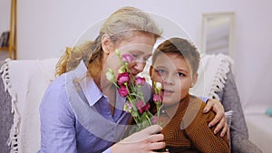 Boy gives flowers to grandmother
