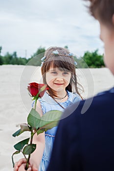 Boy gives a little girl rose