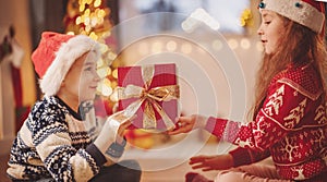 Boy giving red present box to cute girl