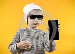 boy in glasses holds a phone with a mockup