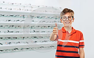 boy in glasses showing thumbs up at optics store