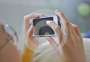 A boy with glasses to sleep cell phone The phone screen is blank, black, slender fingers spread out, slide the screen