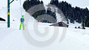 Boy go up holding t-bar ski lift on alpine sport vacations