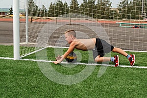 Boy goalkeeper catches soccer ball
