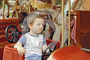 Boy goes for a drive on the rides in the park