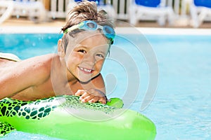 Boy in goggles swimming with inflatable toy