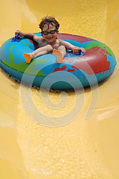 Boy going down slide in waterpark