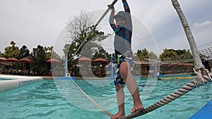 Boy is going down the water slide in an aqua park.