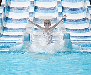 Boy going down water slide in pool