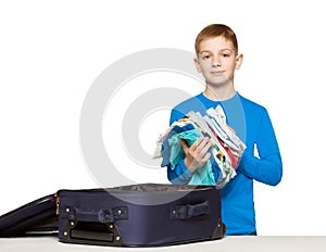 Boy going pack his luggage bag with clothes