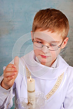 Boy going to the first holy communion with candle