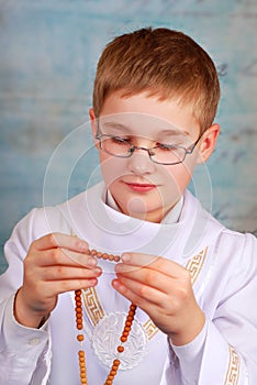 Boy going to the first holy communion with rosary